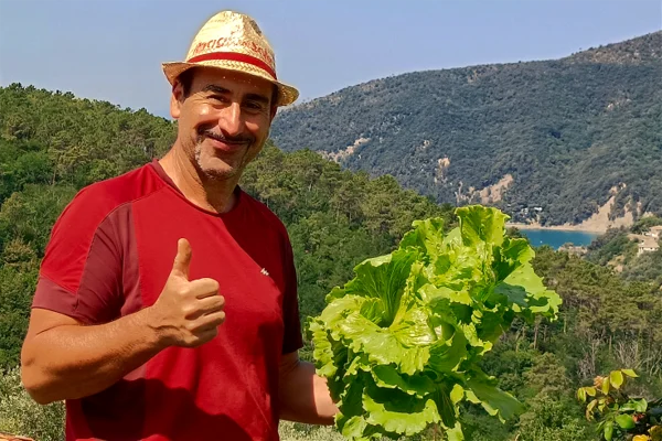 Davide mostra i prodotti genuini dell'Orto dei Rolli con vista mare su Moneglia
